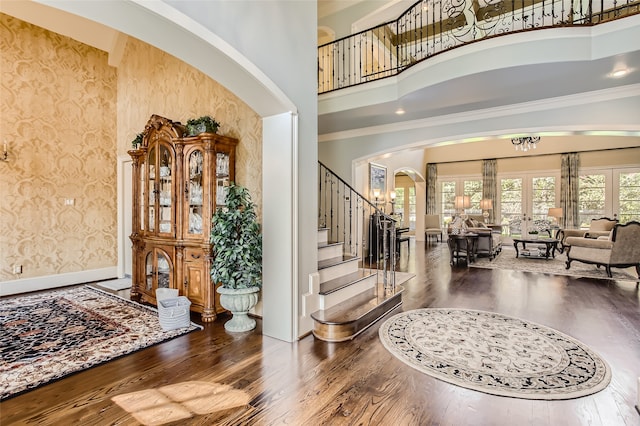 entryway with crown molding, a high ceiling, and hardwood / wood-style flooring