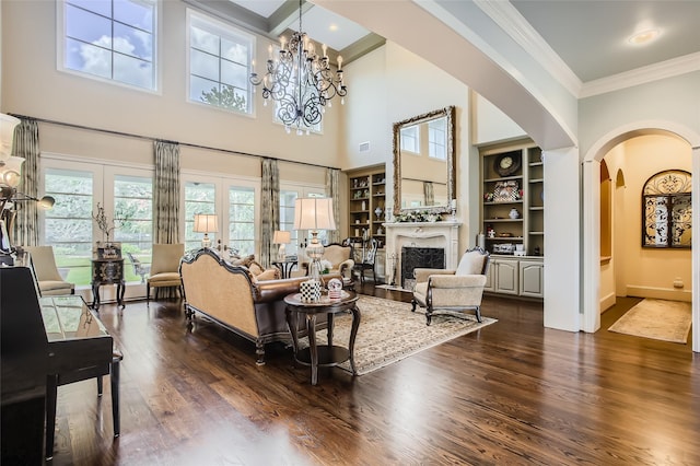 25002 Falling Water Estates Ln, Katy, TX 77494 - living room with arched walkways, dark wood-type flooring, crown molding, a towering ceiling, and a chandelier