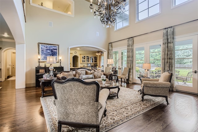 25002 Falling Water Estates Ln, Katy, TX 77494 - living room featuring arched walkways, a high ceiling, plenty of natural light, and dark wood-style flooring