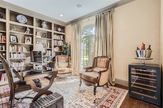 living area with beverage cooler, dark hardwood / wood-style floors, and ornamental molding