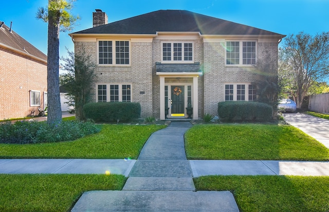 colonial home featuring a front yard