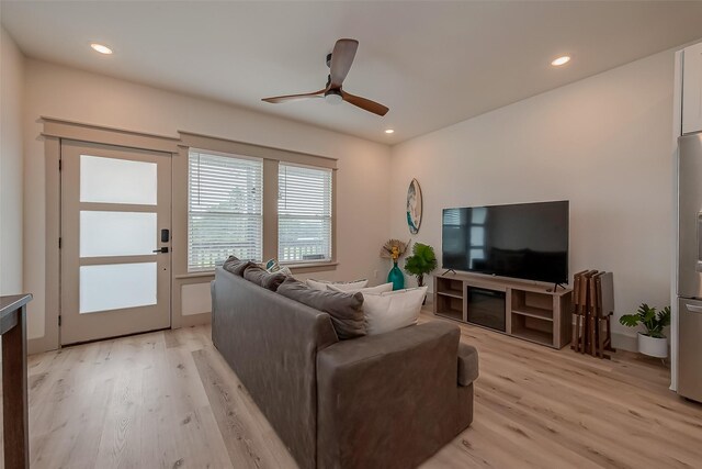 living room featuring light wood-type flooring and ceiling fan