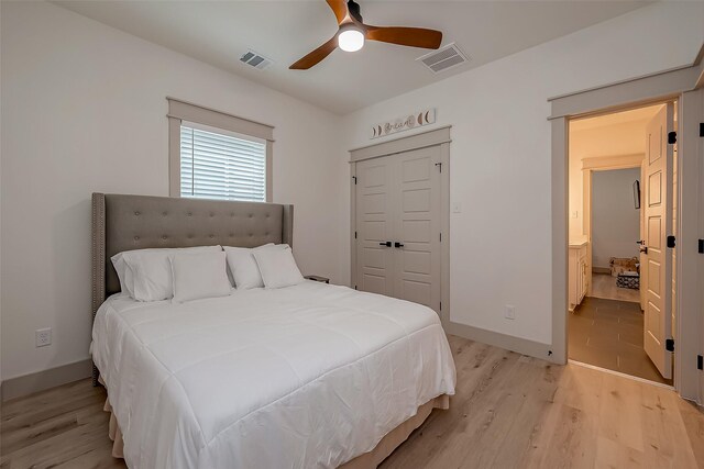 bedroom featuring light hardwood / wood-style flooring, ceiling fan, and ensuite bathroom