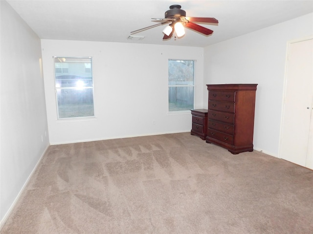 spare room featuring light carpet and ceiling fan