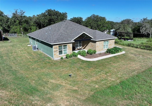 view of front of home featuring central AC and a front yard