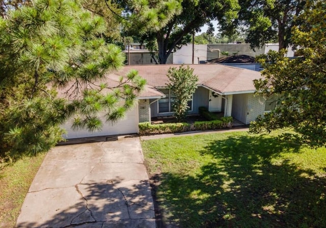 obstructed view of property featuring concrete driveway, brick siding, an attached garage, and a front yard