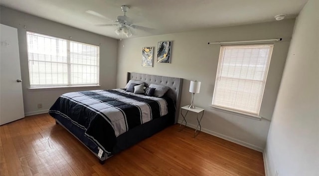 bedroom featuring baseboards, ceiling fan, and wood finished floors