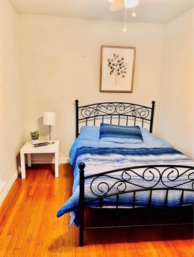 bedroom with baseboards and hardwood / wood-style floors