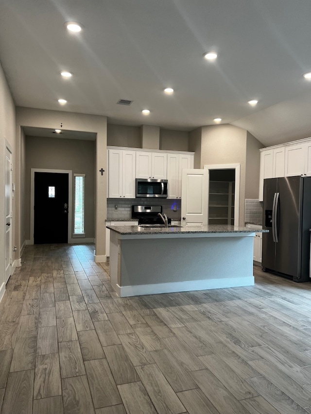 kitchen featuring white cabinets, a kitchen island with sink, light hardwood / wood-style floors, and stainless steel appliances