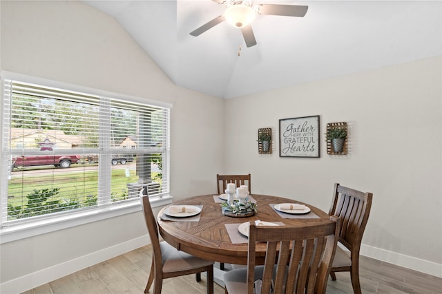 dining room with hardwood / wood-style floors, vaulted ceiling, and ceiling fan