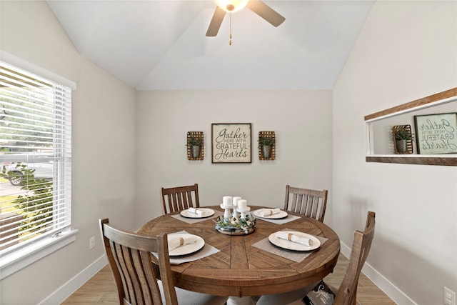 dining space with light wood-type flooring, a wealth of natural light, and lofted ceiling