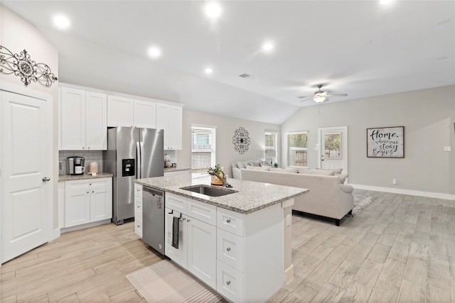 kitchen featuring white cabinetry, sink, vaulted ceiling, and stainless steel appliances