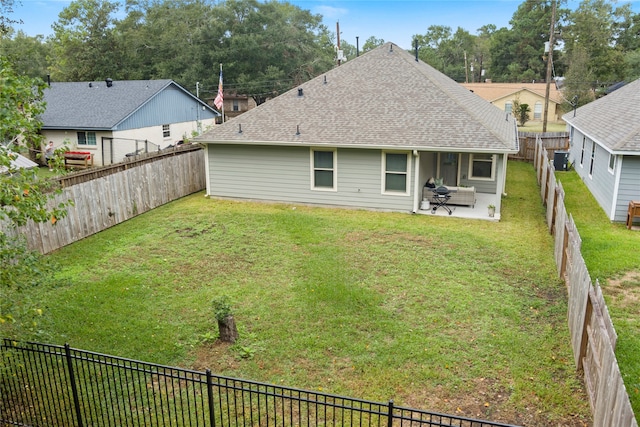 back of house featuring a lawn and a patio area