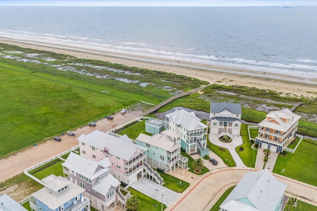 birds eye view of property with a water view and a beach view