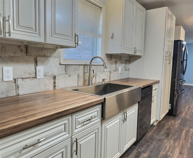 kitchen with black appliances, wood counters, tasteful backsplash, dark wood-type flooring, and sink