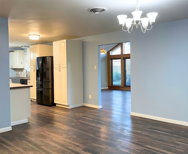 kitchen featuring pendant lighting, dark hardwood / wood-style flooring, and black refrigerator with ice dispenser