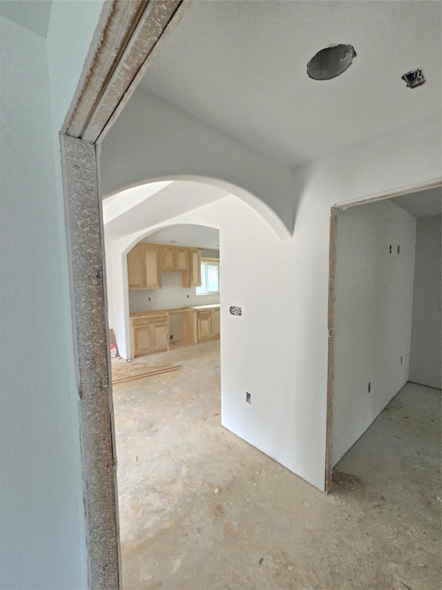 spare room featuring arched walkways