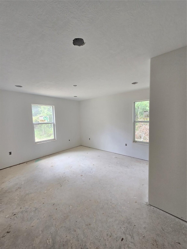 empty room featuring a wealth of natural light and a textured ceiling