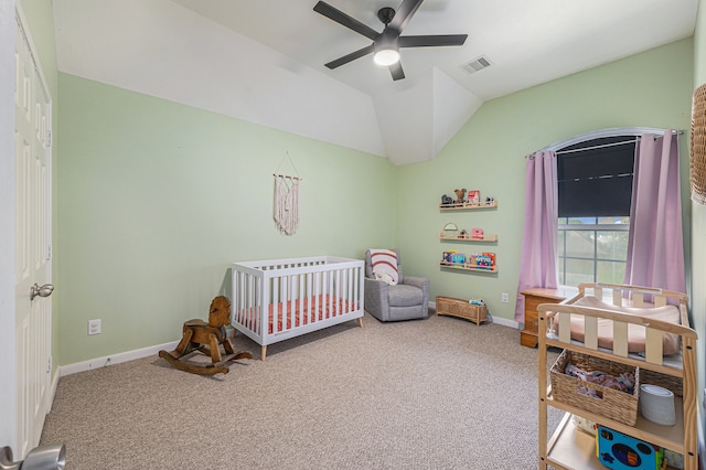 carpeted bedroom with a closet, ceiling fan, a nursery area, and vaulted ceiling