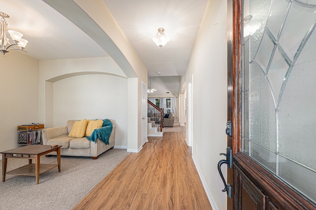 hallway featuring a notable chandelier and hardwood / wood-style floors