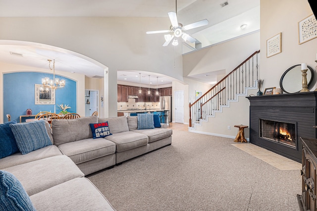 living room featuring light colored carpet, sink, ceiling fan with notable chandelier, and high vaulted ceiling