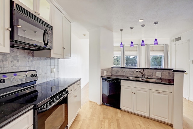 kitchen with black appliances, backsplash, light hardwood / wood-style floors, hanging light fixtures, and white cabinets