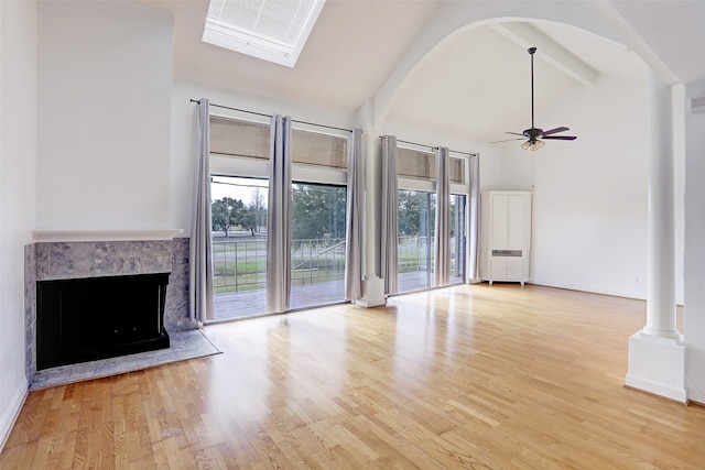 unfurnished living room featuring beamed ceiling, high vaulted ceiling, a premium fireplace, ceiling fan, and light hardwood / wood-style floors