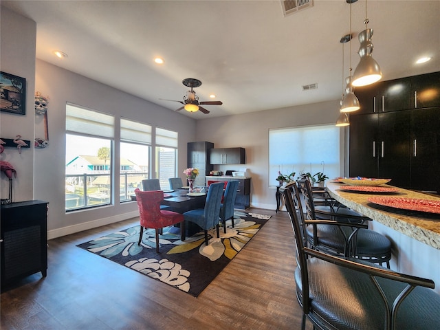 dining room with ceiling fan and dark hardwood / wood-style flooring