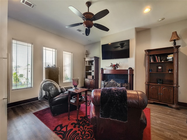 living room featuring ceiling fan and dark hardwood / wood-style floors