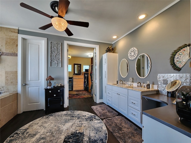 bathroom featuring ceiling fan, a bath, hardwood / wood-style flooring, vanity, and ornamental molding