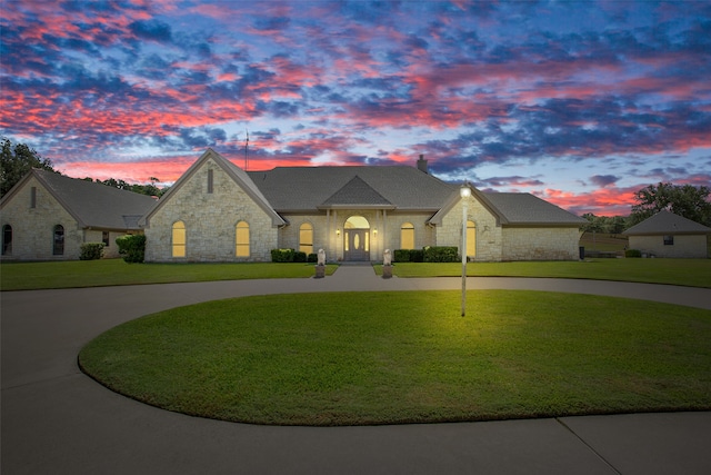 french country inspired facade featuring a lawn