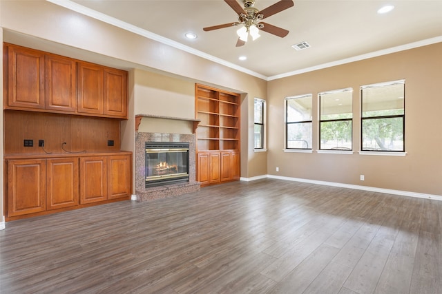 unfurnished living room featuring ceiling fan, ornamental molding, and hardwood / wood-style flooring