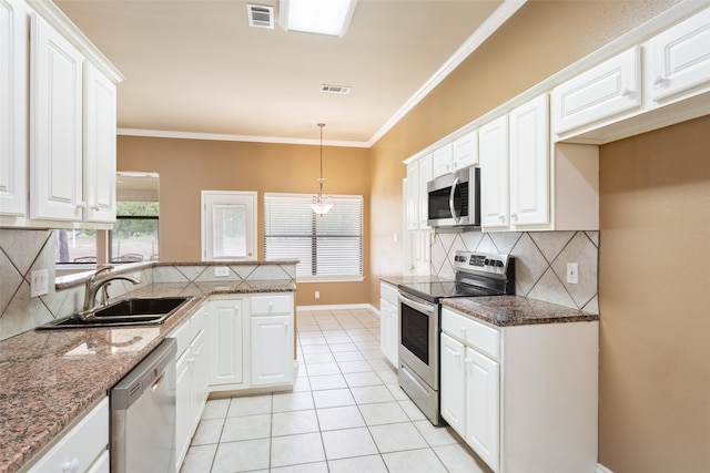 kitchen featuring backsplash, appliances with stainless steel finishes, sink, dark stone countertops, and white cabinets