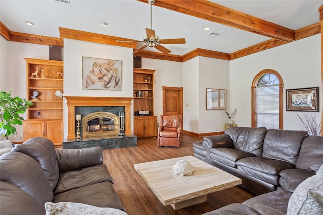 living room featuring a fireplace, hardwood / wood-style flooring, beam ceiling, and ceiling fan