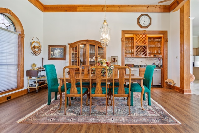 dining area featuring a notable chandelier, hardwood / wood-style floors, beamed ceiling, and sink