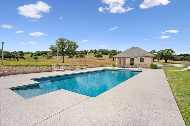 view of swimming pool featuring a yard, an outdoor structure, and a patio