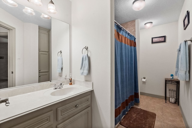 bathroom with vanity, a textured ceiling, and tile patterned flooring