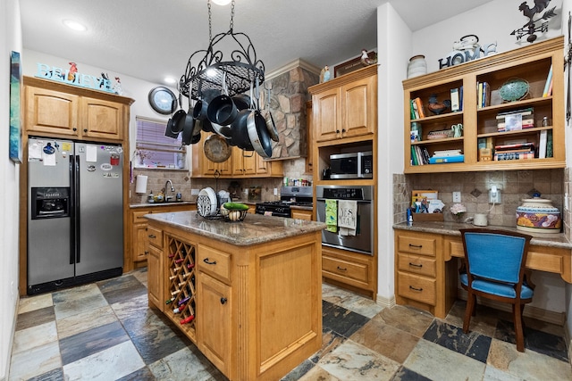 kitchen featuring appliances with stainless steel finishes, built in desk, a center island, and decorative backsplash