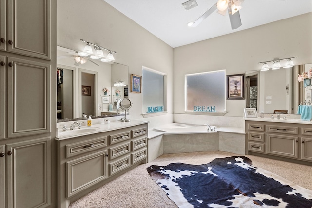 bathroom featuring vanity, a relaxing tiled tub, and ceiling fan