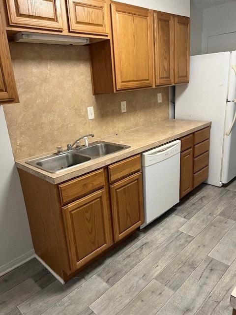 kitchen with light hardwood / wood-style flooring, sink, white appliances, and decorative backsplash