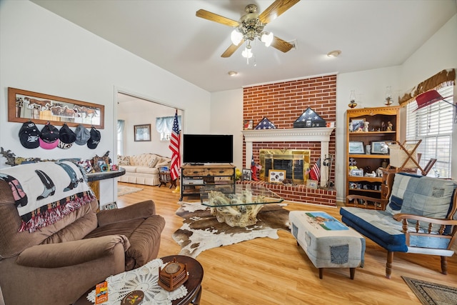 living room featuring a fireplace, hardwood / wood-style flooring, and ceiling fan