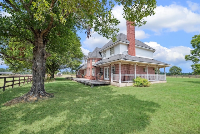 rear view of property featuring a lawn and a wooden deck