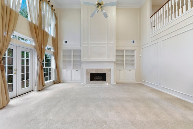 unfurnished living room featuring light carpet, french doors, and a high ceiling