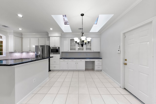 kitchen with backsplash, hanging light fixtures, white cabinetry, stainless steel appliances, and an inviting chandelier