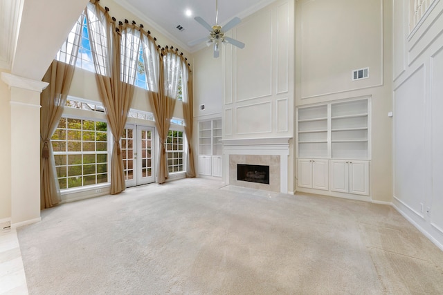 unfurnished living room with ornamental molding, a high ceiling, and light colored carpet