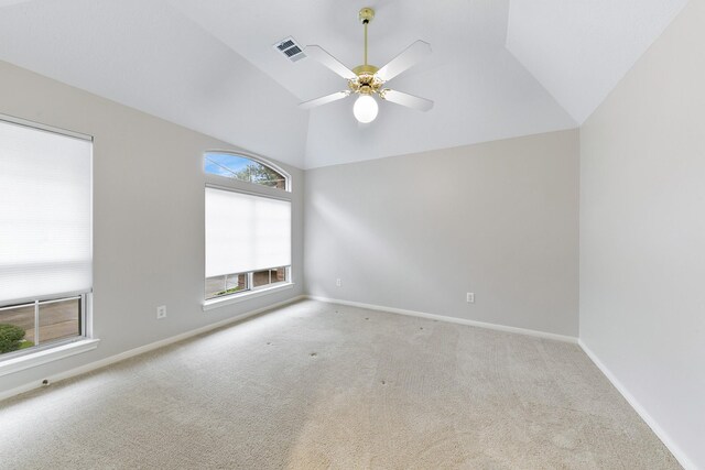 spare room with ceiling fan, light colored carpet, and vaulted ceiling