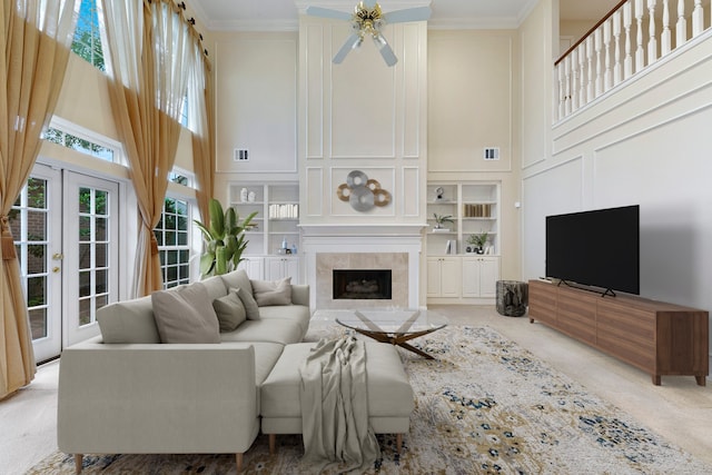 carpeted living room with a high ceiling, crown molding, french doors, and ceiling fan