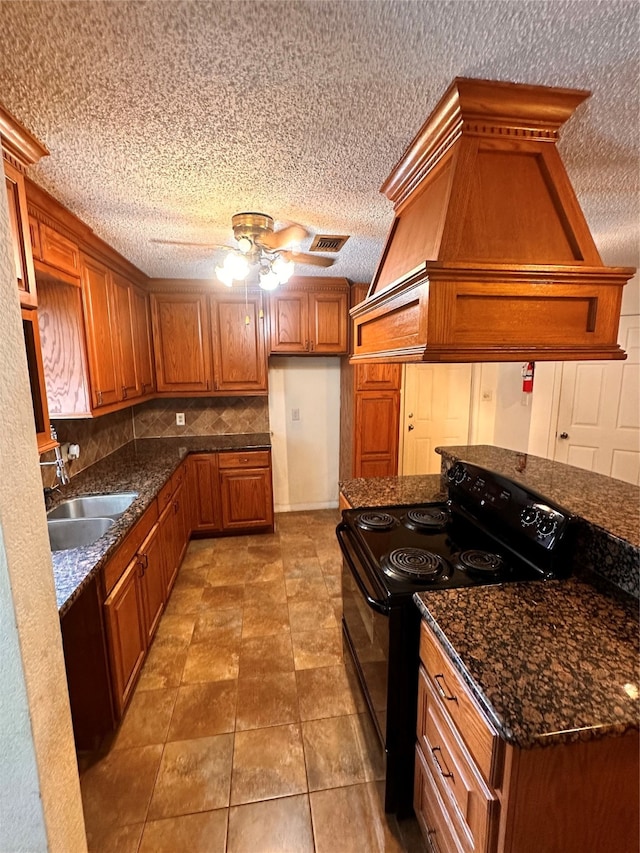 kitchen featuring custom exhaust hood, a textured ceiling, sink, ceiling fan, and black / electric stove