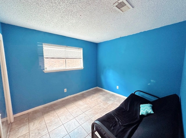 unfurnished room featuring a textured ceiling and light tile patterned flooring