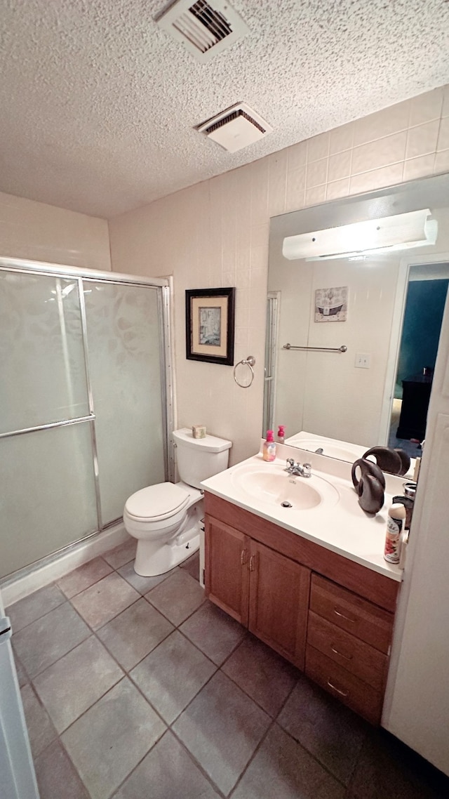 bathroom with vanity, toilet, walk in shower, and tile patterned floors